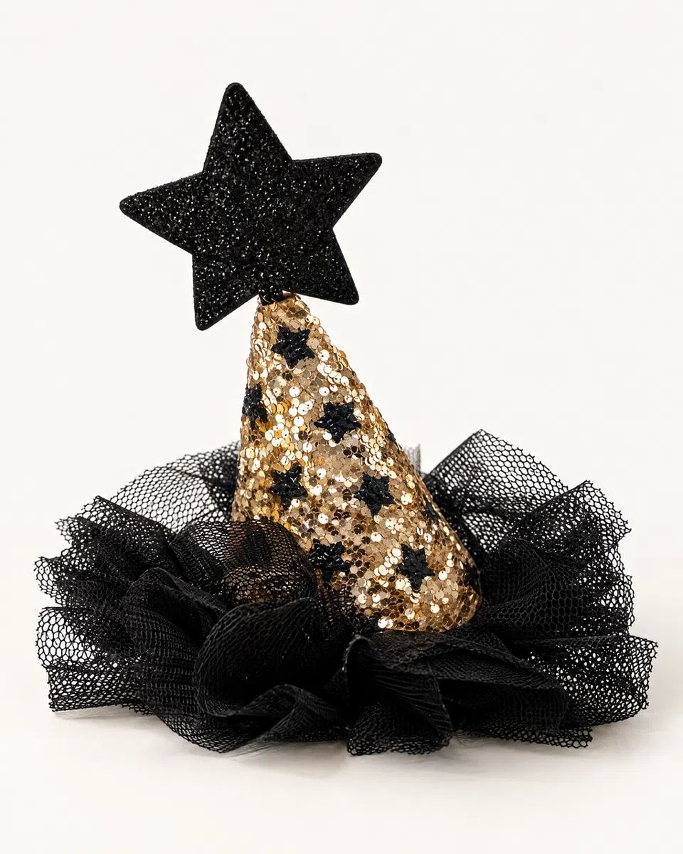 The gold sequin witch hat clip on a white background: a gold sequin cone with black stars, a glittery black star on the tip and a ruffled black tulle brim