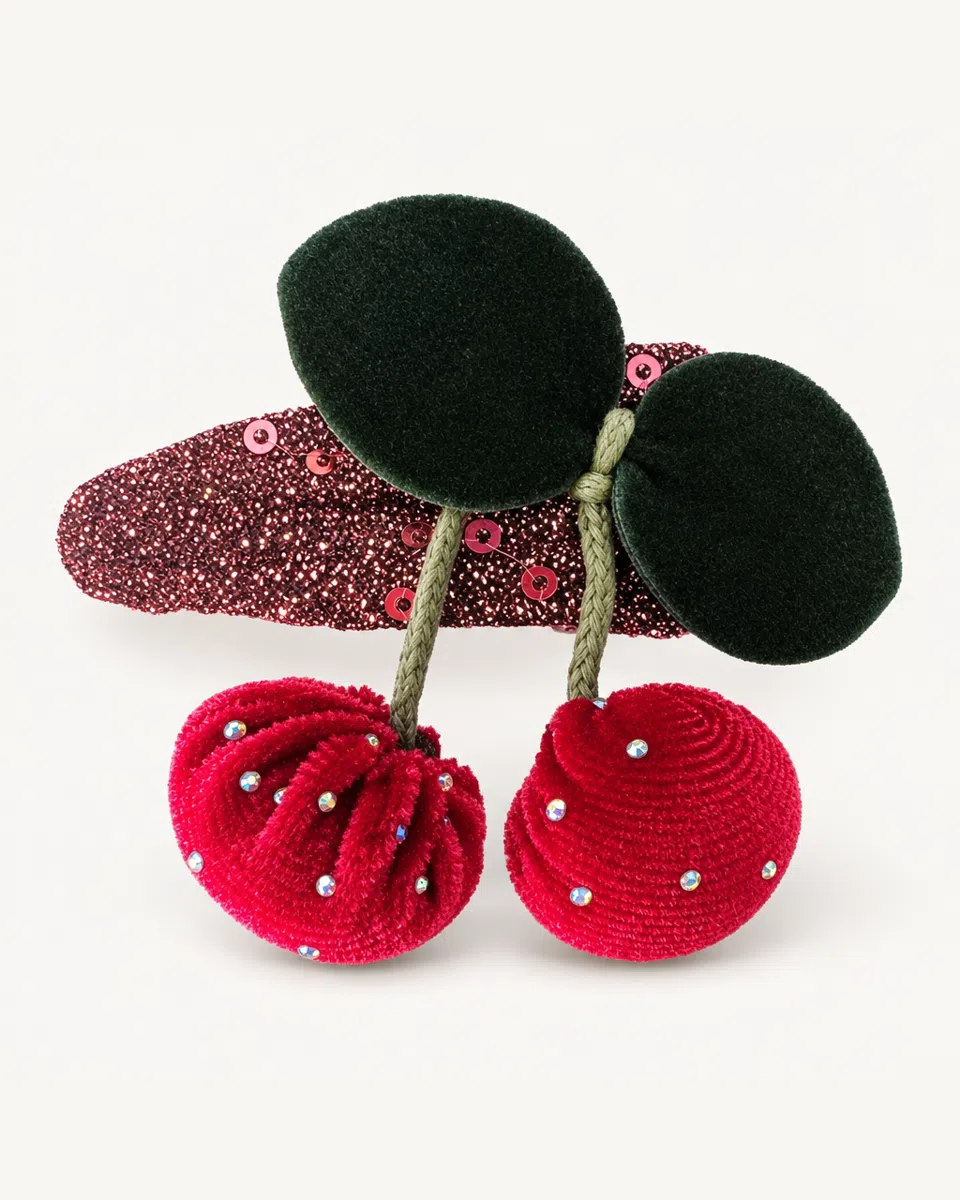 The velvet cherry hair clip on a white background