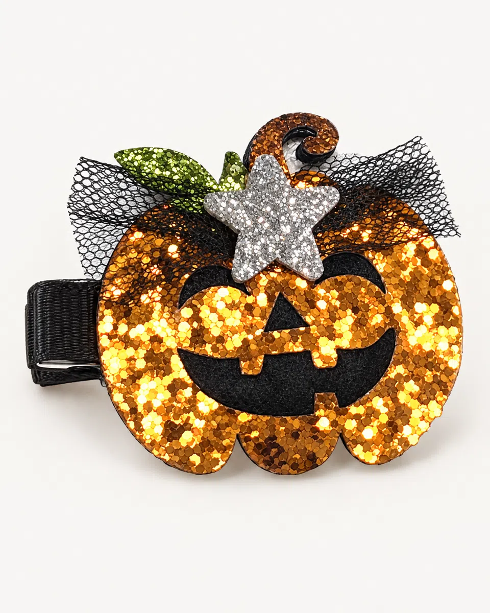 The glitter pumpkin clip on a white background: an orange glitter jack-o'-lantern with a curly stem, a green leaf, a silver star and black tulle