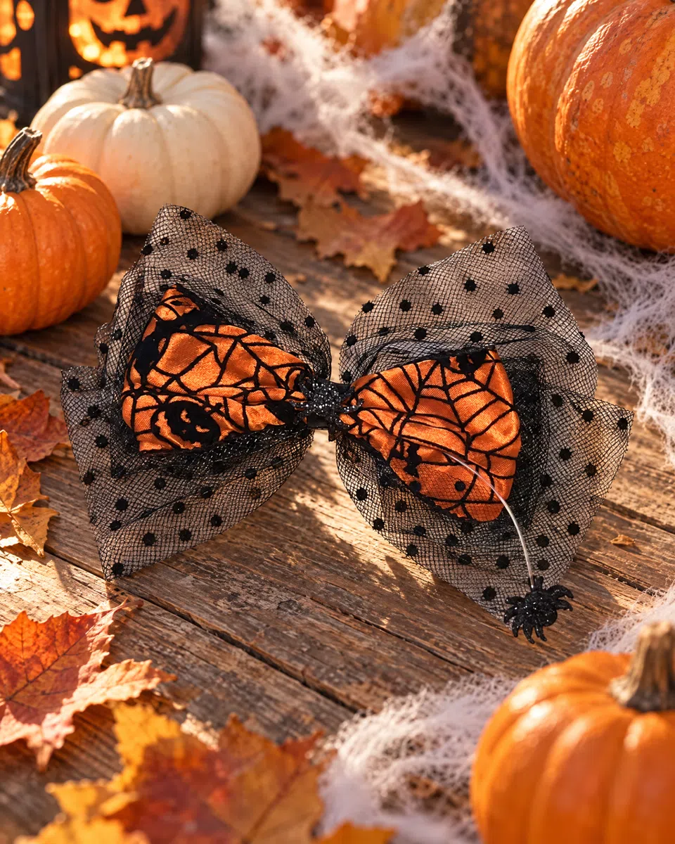 The bow on weathered timber among pumpkins, fallen leaves and fake cobwebs