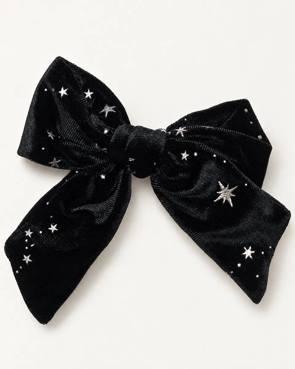 The velvet star bow clip on a white background: a big black velvet bow scattered with little silver stars