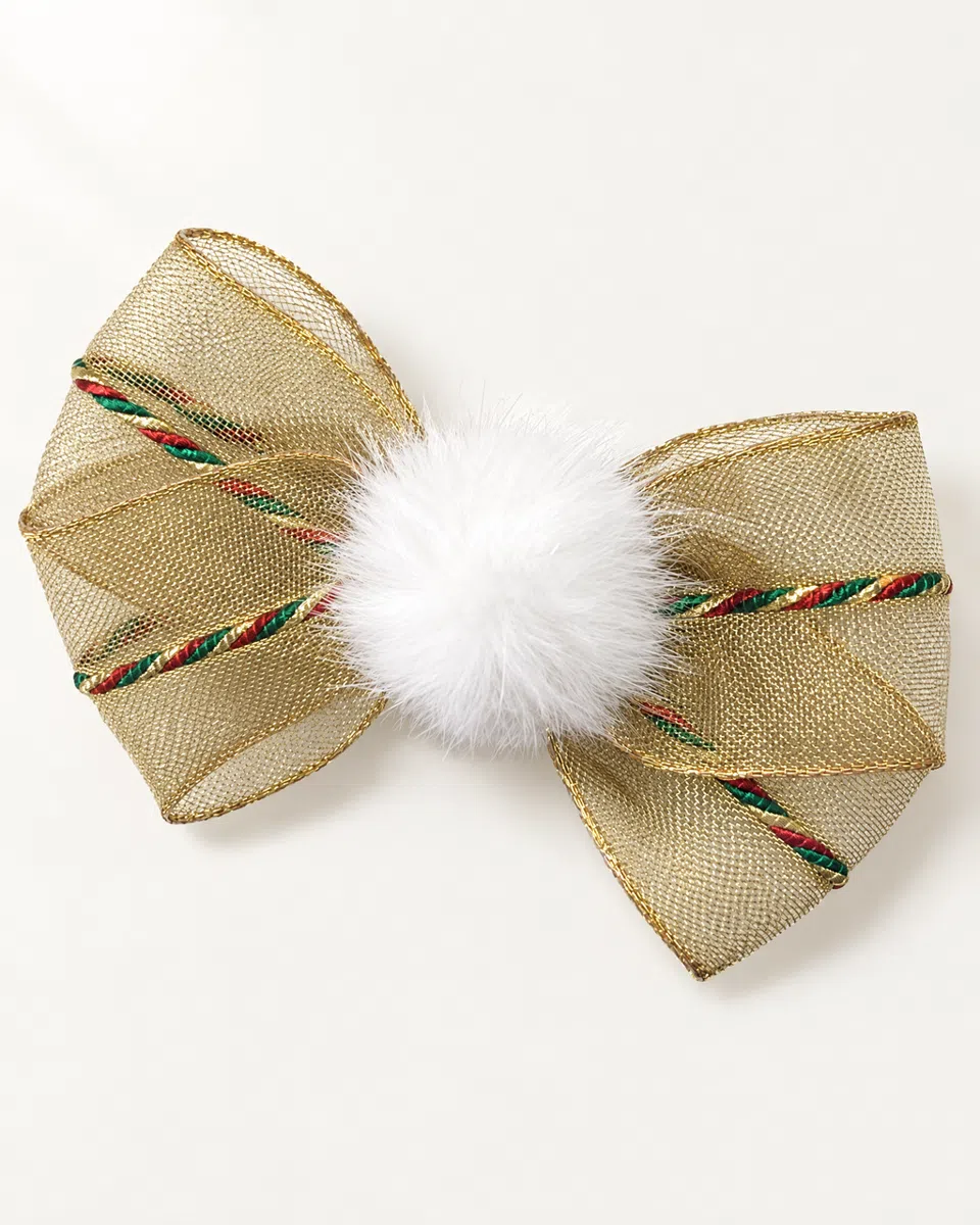 The gold pom-pom bow clip on a white background: sheer gold mesh with a red, green and gold cord, and a fluffy white pom-pom in the middle